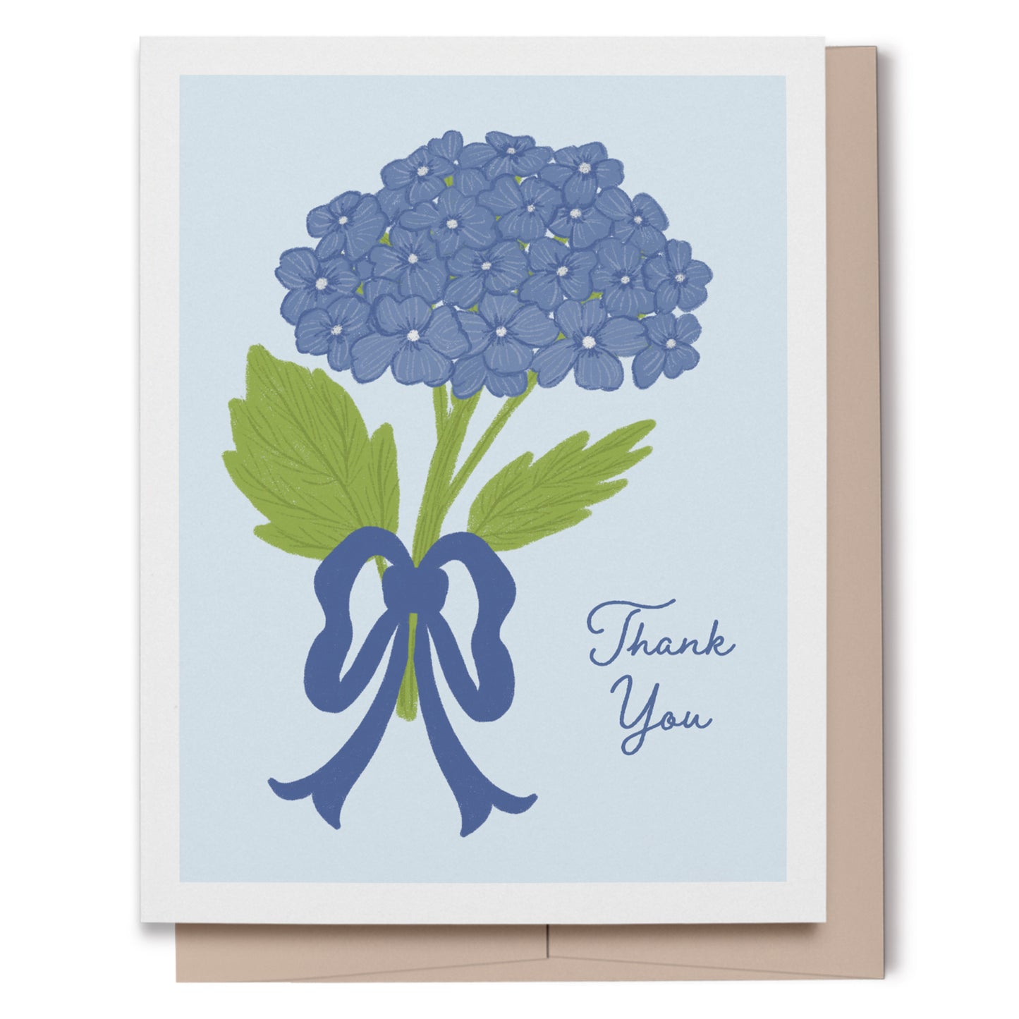 A greeting card with a white border, featuring a hand drawn illustration of blue hydrangea flowers with green leaves tied with a blue ribbon, next to the words 'Thank You' in blue script. The card is shown with a beige envelope behind it on a white background.