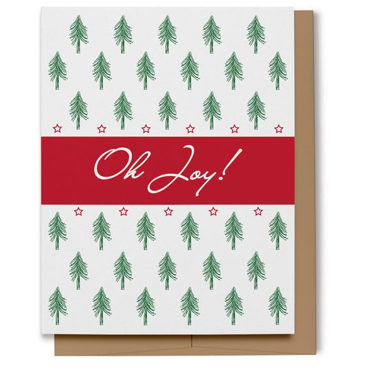 Christmas card featuring a pattern of pine trees with a red block in the middle with white text which reads, "Oh Joy!"